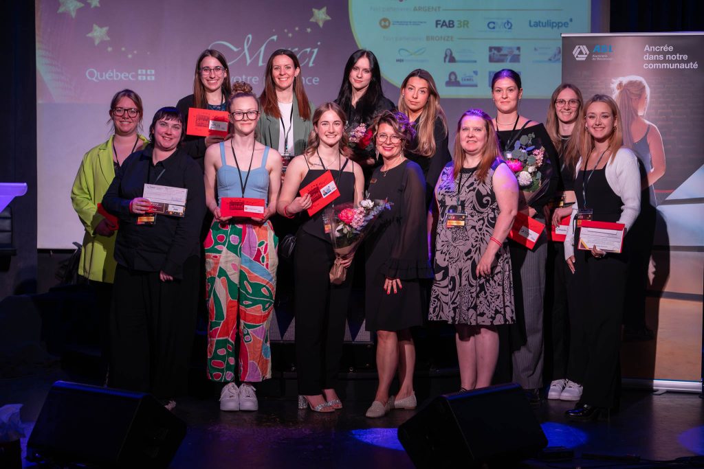 Les 10 récipiendaires, accompagnées d’Annie Brassard, directrice du Centre Le Pont (au centre devant) et Émilie Boissonneault, représentante du partenaire présentateur de la soirée, ABI (2e sur la rangée du haut).  Une photo originale est disponible au besoin. Crédit-photo : Jean-Sébastien Désilets, photographe